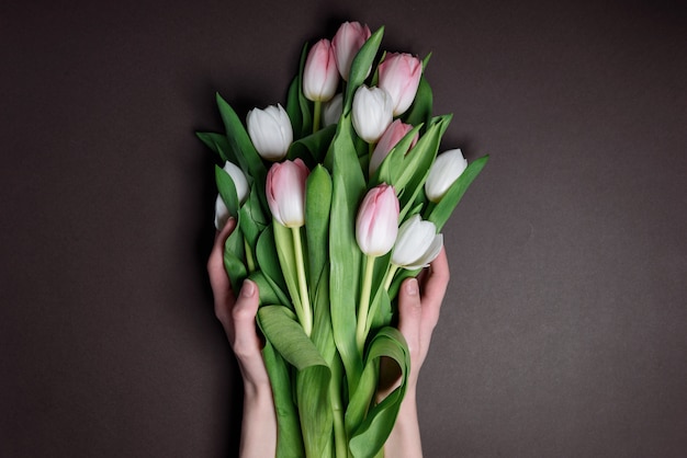 Foto mãos com tulipas. o conceito de colocar flores para heróis caídos