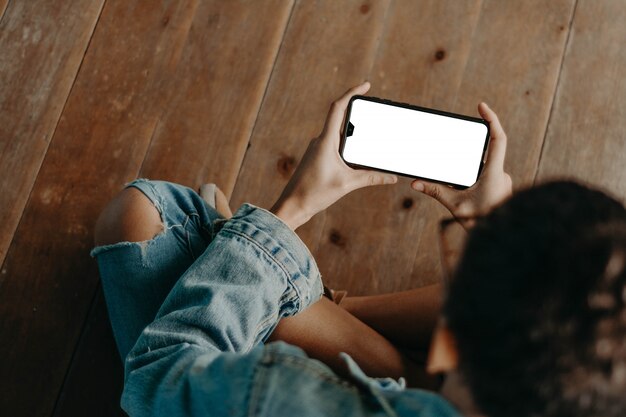 Mãos com um telefone preto. Smartphone