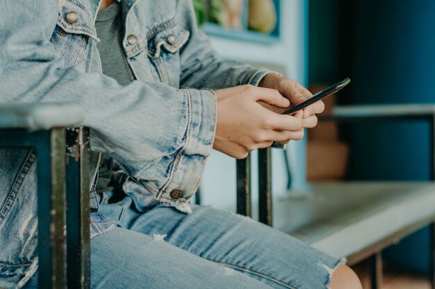 Mãos com um telefone preto. Smartphone