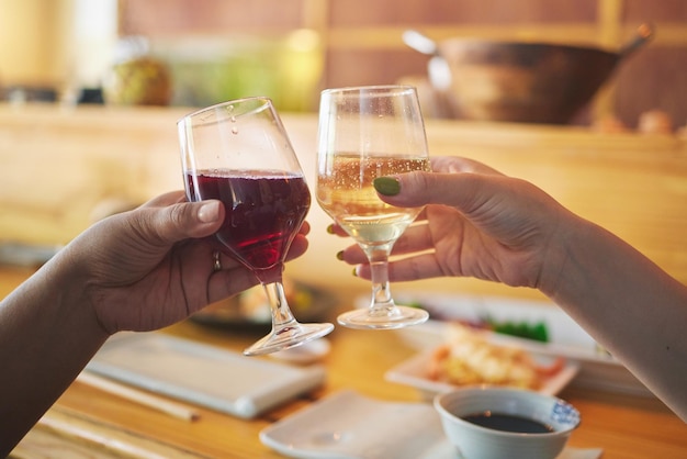 Mãos copo de vinho e amigos brindam no restaurante em celebração juntos Álcool torce e as pessoas bebem champanhe em cafés em festas de ligação ou refeições requintadas em eventos de luxo com comida na mesa