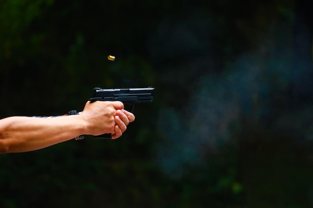 Foto mãos cortadas a disparar uma arma.