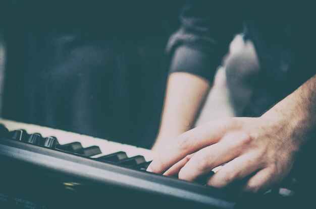 Foto mãos cortadas a tocar piano.