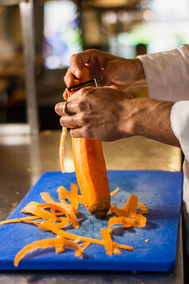 Foto mãos cortadas de chef descascando legumes