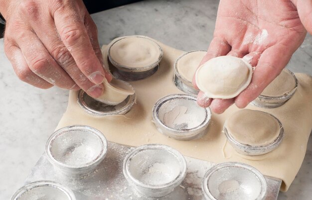 Mãos cortadas de chef preparando comida na mesa em uma cozinha comercial