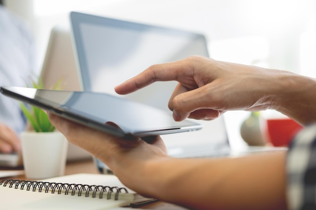 Foto mãos cortadas de empresário usando tablet digital no escritório