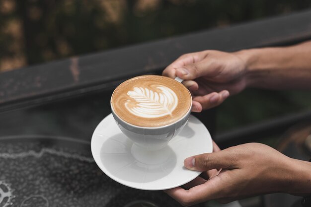 Mãos cortadas de mulher segurando café na mesa