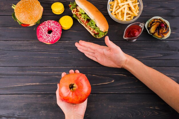 Foto mãos cortadas de mulher segurando frutas na mesa