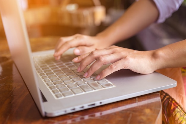 Foto mãos cortadas de mulher usando laptop