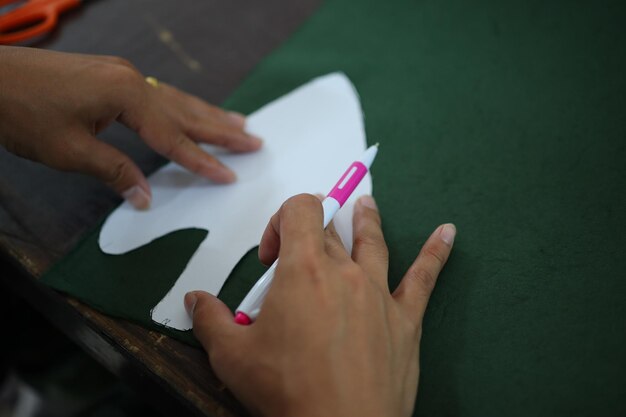 Mãos cortadas de pessoa desenhando com papel na mesa