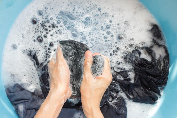 Foto mãos cortadas de pessoa lavando roupa em balde