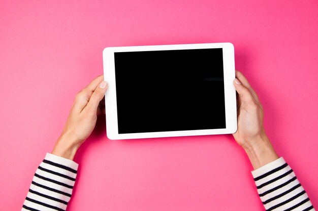 Foto mãos cortadas de pessoa segurando tablet digital na mesa