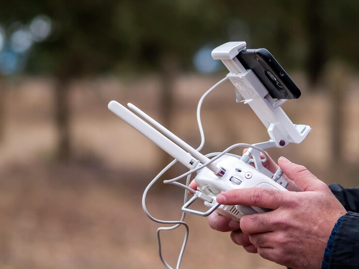 Foto mãos cortadas de pessoa usando controle remoto de drone e telefone celular