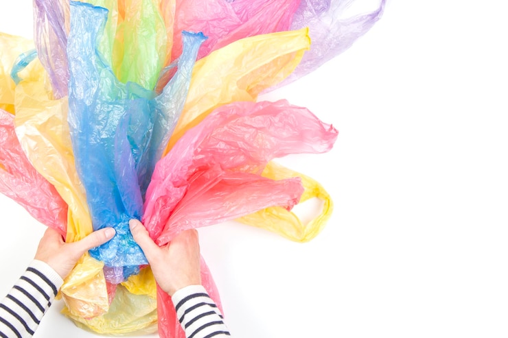 Foto mãos cortadas de sacos de plástico coloridos sobre fundo branco