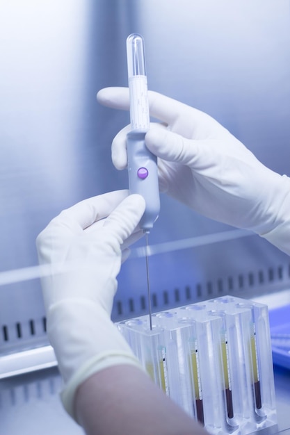 Mãos cortadas de um cientista usando seringa em laboratório