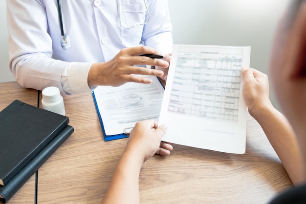 Mãos cortadas de um paciente masculino discutindo o relatório com o médico na clínica