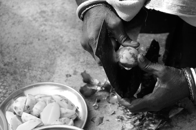 Foto mãos cortadas de uma mulher a descascar batatas