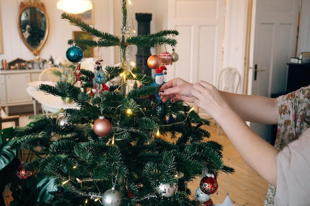 Mãos cortadas decorando a árvore de Natal