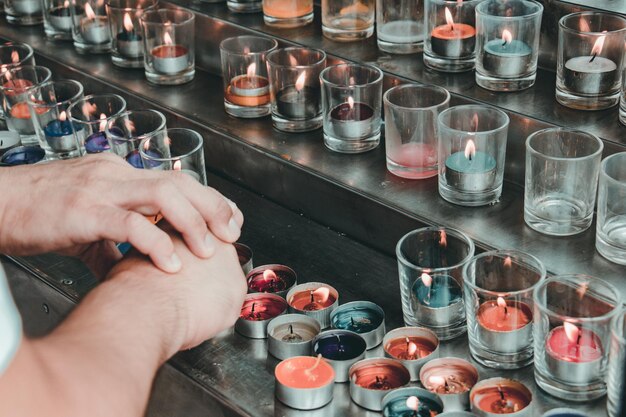 Foto mãos cortadas por velas de chá acesas nos degraus