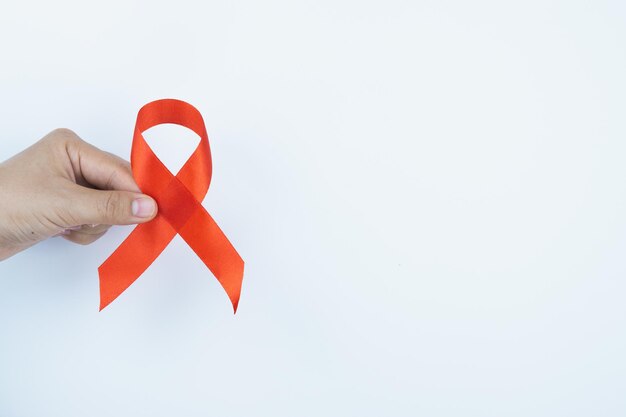 Foto mãos cortadas segurando fita vermelha de conscientização sobre o hiv
