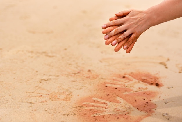 Mãos cortadas sobre a areia na praia