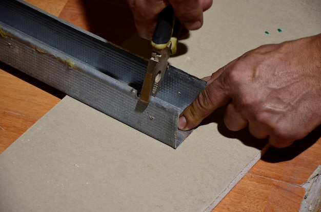 Mãos cortadas usando alicates em metal em oficina