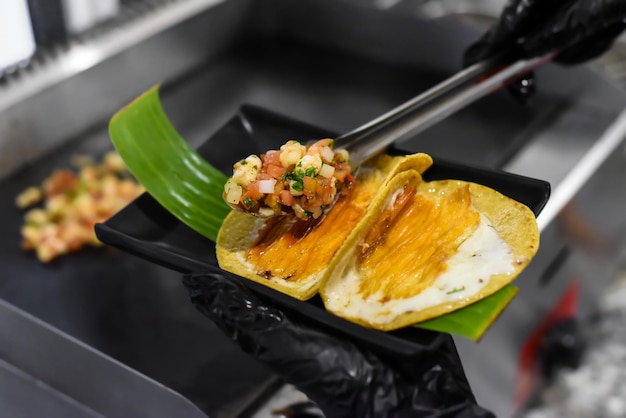 Mãos cozinhando tacos em um restaurante mexicano