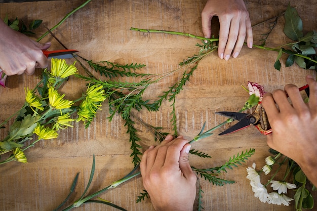 Mãos da florista preparar buquê de flores