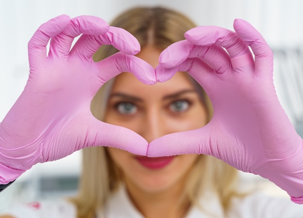 Mãos da médica mostrando a forma do coração. Closeup de mãos do médico. Ajuda médica, profilaxia ou conceito de seguro. Atenção cardiológica, saúde, proteção e prevenção. Conceito de coração saudável