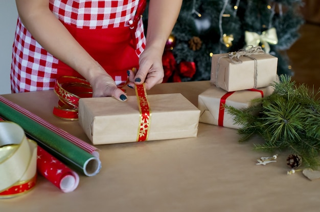 Mãos da mulher embalando presentes de Natal embrulhando presente para presentes de Natal e Ano Novo