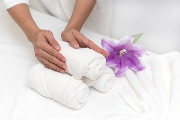 Mãos da mulher que ajustam a decoração do bem-estar no fundo do salão do spa