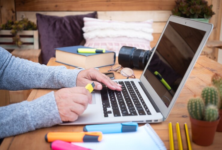 Foto mãos da mulher sênior trabalhando no laptop mesa de madeira escritório alternativo ao ar livre para trabalho remoto