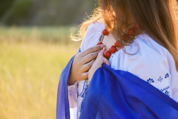 Mãos de adolescente com uma bandeira ucraniana nos ombros