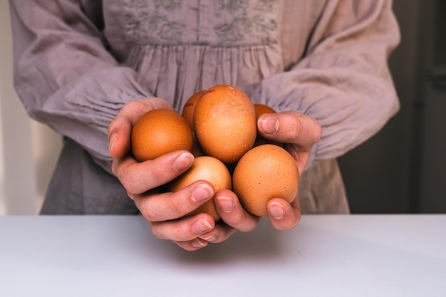 mãos de agricultora segurando ovos
