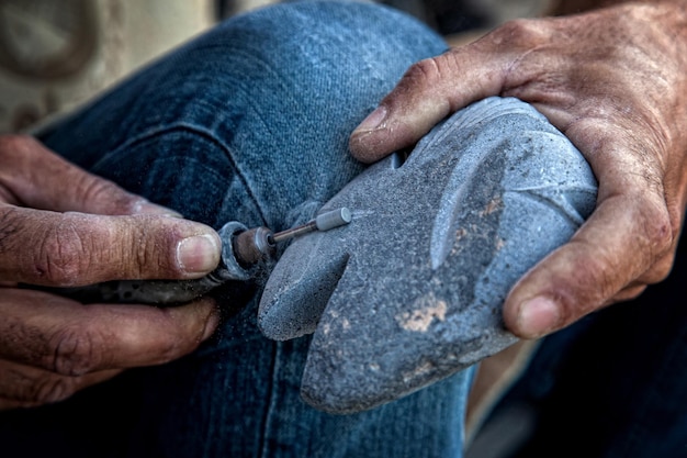 mãos de artesão trabalhando pedaço de pedra