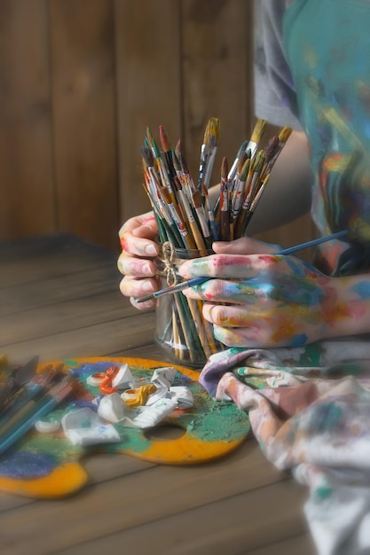 Mãos de artista feminina com pincéis