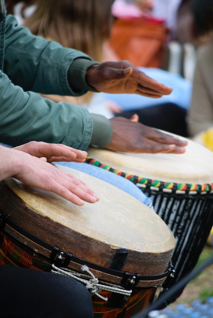 Mãos de baterista tocando o tambor étnico djembe