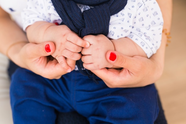 Mãos de bebê da família. Mãe segurando filho recém-nascido. Criança mão closeup em pais.