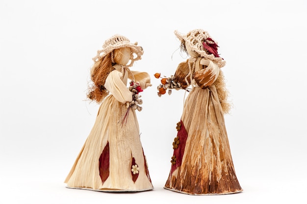 Mãos de boneca de casca de milho com flores o branco