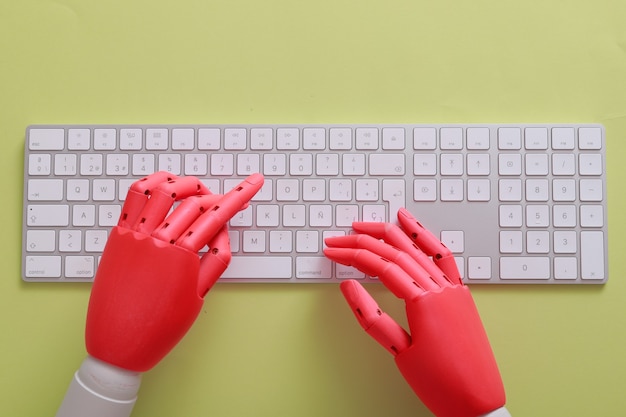 Mãos de boneco laranja em um teclado com fundo verde