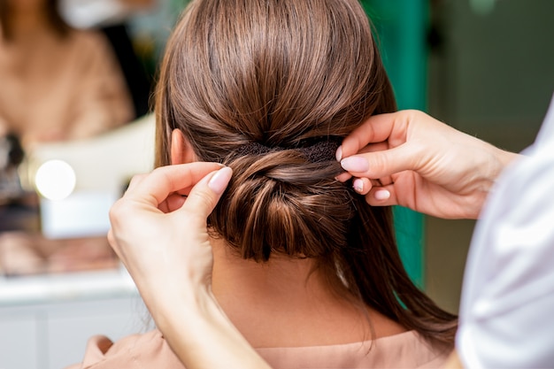 Mãos de cabeleireiro fazendo penteado.