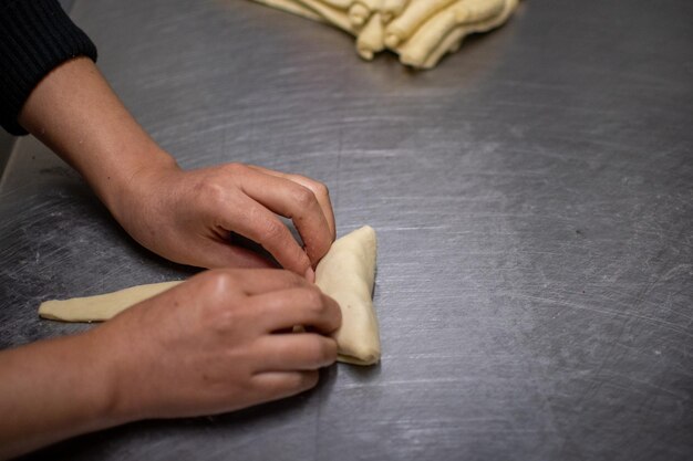 Mãos de chef de pastelaria fazendo croissants