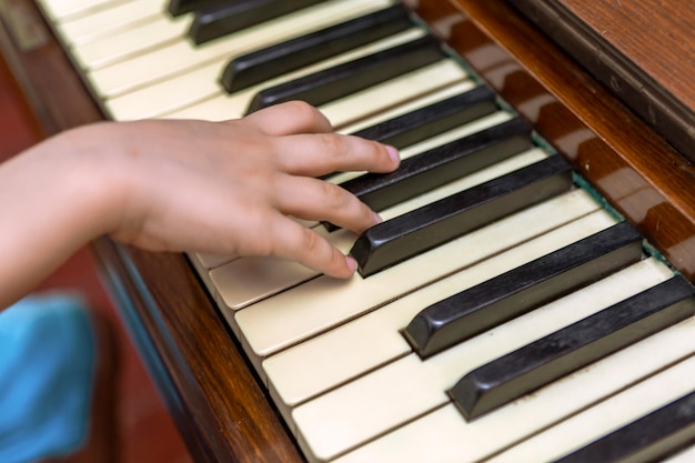 Mãos de Child39s nas teclas de piano fotografia aproximada