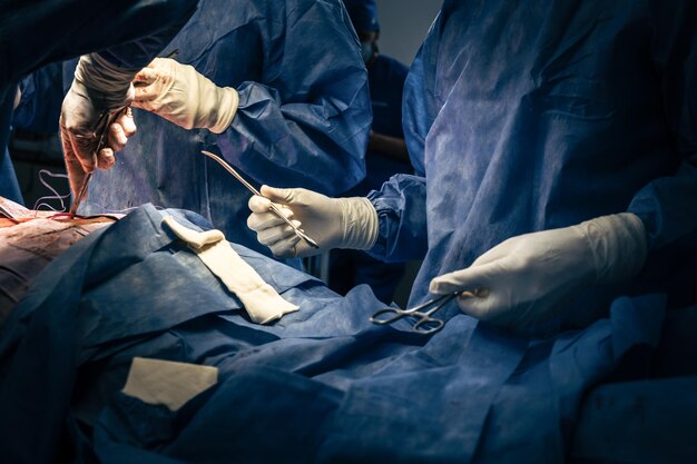 Foto mãos de cirurgiões e assistentes cirúrgicos com suprimentos cirúrgicos