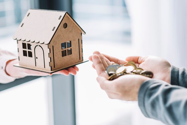 Foto mãos de close-up com casa e dinheiro