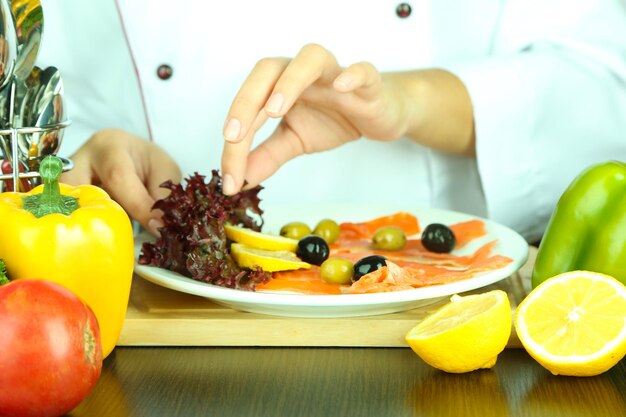 Foto mãos de cozinheiro decorando prato