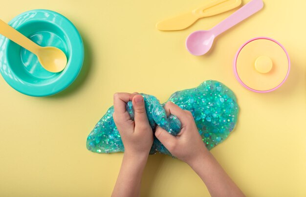 Mãos de criança brincando com lodo e apertando-o, um brinquedo para aliviar o estresse para crianças