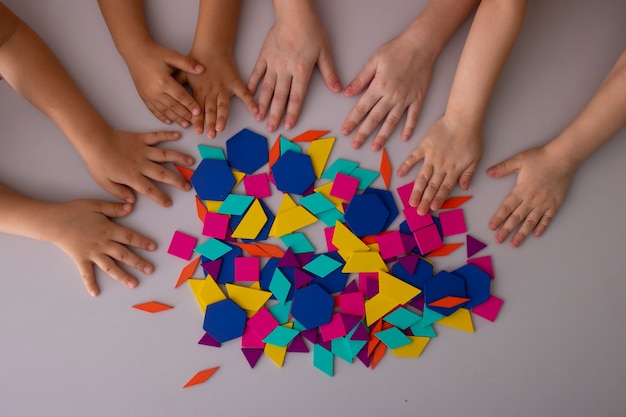 Mãos de crianças brincando com blocos coloridos