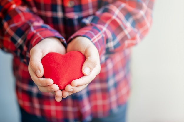 Mãos de crianças dando coração vermelho e amor no dia dos namorados.