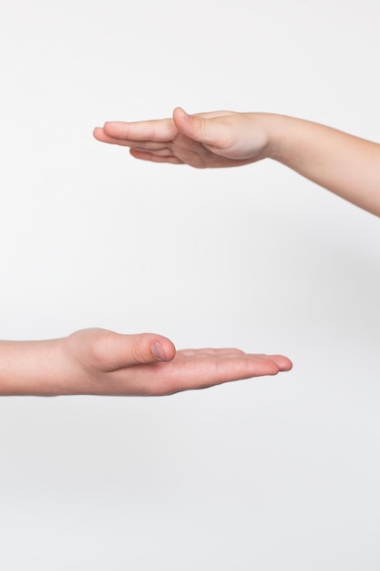 Mãos de crianças gesticulando em um fundo branco saudação masculina