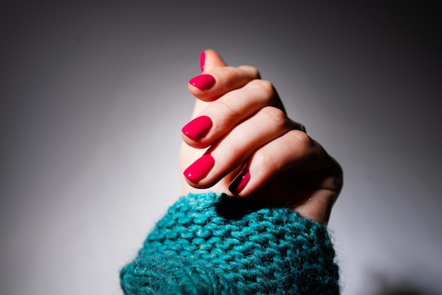 Mãos de design de unhas com manicure de verão rosa em fundo cinza close-up de unhas de arte de mãos femininas